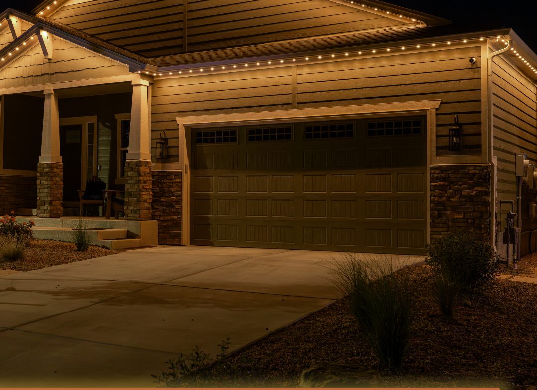 A home's garage and porch lit in warm amber light